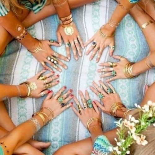 des mains de femmes posées en cercle au sol